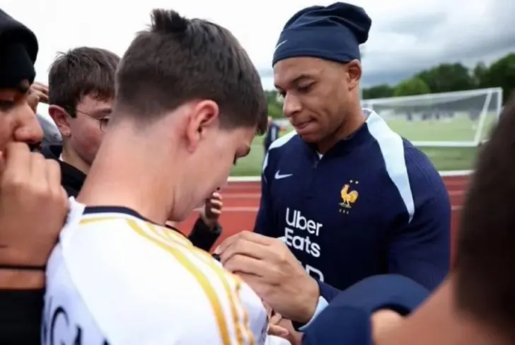 Mbappé firmando la camiseta del Madrid, su próximo equipo.